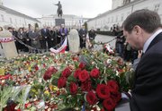 Staff of the Presidential Palace, background, conduct a prayer in Warsaw, Poland, on Saturday as news broke out about Polish President’s Lech Kaczynski death. Polish President Lech Kaczynski and his wife died Saturday along with 130 others when their plane crashed while coming in for a landing in western Russia.
