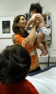 Nurse practitioner Amanda Cockrell examines 6-month-old Lucas Olofson on March 22 at Rush Lifetime Medical Associates in Chicago, while his brother Jayden Cardenas, 3, watches.