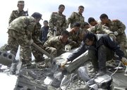 Rescuers search for survivors in the ruins Wednesday after an earthquake at Jiegu township in Yushu county, western China’s Qinghai province. Soldiers and civilians used shovels and their bare hands to dig through collapsed buildings in search of survivors after strong earthquakes struck a mountainous Tibetan region of China on Wednesday, killing hundreds of people.