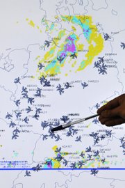 A member of the German Air Traffic Control center crisis management group points at a map showing the current air traffic in the sky Tuesday over Germany, in Langen, near Frankfurt, Germany.