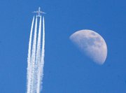 An aircraft passes the moon Thursday over Frankfurt, central Germany. German air traffic went back to normal Thursday following airspace closure because of the volcanic ash cloud that came from Iceland.