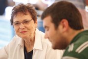 Phi Kappa Psi house mother Esther Wolfe smiles as she sits for dinner with members of the fraternity.