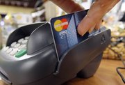 A customer swipes a MasterCard debit card through a machine while checking out at a shop Nov. 2, 2009, in Seattle. Congress may be poised to tighten restrictions on the fees that businesses pay when customers make debit card payments.