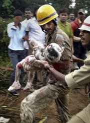 Indian firefighters carry a child, who is believed to have died, out of the debris of an Air India plane that crashed Saturday in Mangalore, in the southern Indian state of Karnataka. The plane arriving from Dubai crashed Saturday morning after it overshot a runway while trying to land in southern India, and officials feared as many as 150 people on board were killed.
