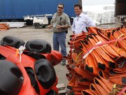 BP PLC CEO Tony Hayward, right, looks at oil booms as he visits a Coast Guard command center Sunday in Venice, La. BP’s stock is taking a hit but the company is expected to survive the worst oil spill in U.S. history.