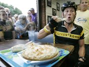 Seven-time Tour de France winner Lance Armstrong eats a piece of coconut cream pie in Sully, Iowa, in this July 27, 2006, file photo during a seven-day bike ride across Iowa. Though many athletes eat before training, some scientists say that if you really want to get rid of more fat, you should skip the pre-workout snack.