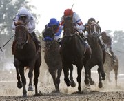 Drosselmeyer, left, approaches the finish of the 142nd Belmont Stakes. Jockey Mike Smith led the 13-to-1 underdog to victory on Saturday in Elmont, N.Y.
