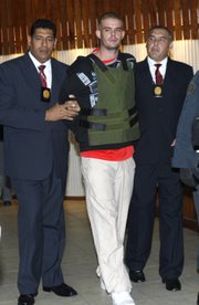 Police officers escort Joran Van der Sloot, center, during a press conference Saturday at a police station in Lima. The young Dutchman wanted in the murder of a 21-year-old Peruvian woman, and who also remains the lone suspect in the 2005 disappearance of U.S. teen Natalee Holloway, arrived in Peru’s capital Saturday to face justice, after being handed over by Chilean police on Friday at the two countries’ border.