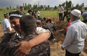 Uzbek men mourn Tuesday during funeral ceremony of a victim who died after ethnic rioting between Kyrgyz and ethnic Uzbeks, in the southern Kyrgyz city of Osh. Ethnic rioting has killed at least several hundred people, roughly double official figures, the Red Cross said Tuesday, as new reports strengthened suspicions that the rioting in Kyrgyzstan was deliberately started.