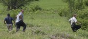 Law enforcement officers chase after a suspect in a stabbing along the bike path near Clinton Lake. A man was arrested after a 15-minute manhunt between the YSI softball fields and the Clinton Lake Dam Wednesday, June 16, 2010.