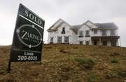 A sold sign is posted outside a home under construction in this June 2 photo in Cincinnati. Home construction plunged last month to the lowest level since December as builders scaled back without a federal tax credit to lure buyers. Building permits also fell, a sign the construction industry won’t fuel the economic recovery.