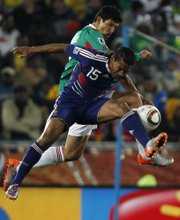 Mexico’s Francisco Javier Rodriguez, back, competes for the ball with France’s Florent Malouda during the World Cup Group A soccer match Thursday at Peter Mokaba Stadium in Polokwane, South Africa. Mexico knocked off France, 2-0, to move to 1-0-1 in group play. France fell to 0-1-1.