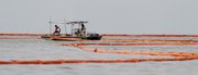 Workers move a boom collecting oil from the Deepwater Horizon spill off Queen Bess Island, in this June 16 file photo near Grand Isle, La. Investors aren’t concerned just yet about BP’s $20 billion claims fund, which is just a drop in the bucket for the deep-pocketed oil giant.