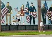 An unidentified person walks past a patriotic mural in Fremont, Neb., in this photo taken Saturday. Fremont voters on Monday approved a measure to ban hiring of or renting property to illegal immigrants.