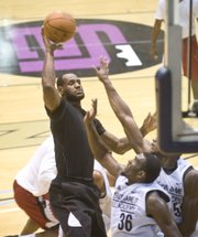 NBA free-agent LeBron James, black shirt, takes a shot over Florida State defender Chris Singleton (36) during a scrimmage at the LeBron James Skills Academy on Monday in Akron, Ohio.