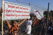 A Palestinian boy holds up a banner referring to captured Israeli soldier Gilad Schalit during a protest calling for the release of Palestinian prisoners from Israeli jails Monday on the Palestinian side of the Erez checkpoint with Israel, in Beit Hanoun, northern Gaza Strip.