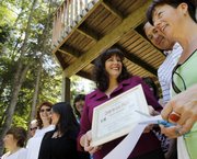 Sylvie Nelson, executive director for the Saranac Lake Area chamber of commerce, center, attends a ribbon cutting ceremony for a yoga studio June 18 in Saranac Lake, N.Y. Nelson, a 44-year-old white woman, keeps getting snared at the Canadian border because she apparently shares some key identifying information with a black man, possibly from Georgia, who is in trouble with the law.