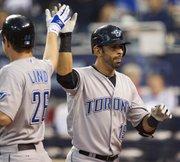 Toronto’s Jose Bautista, right, celebrates with Adam Lind after hitting a two-run home run. The Blue Jays routed the Royals, 13-1, Tuesday in Kansas City, Mo.