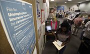 A poster that explains ways to file for unemployment insurance benefits is shown as job seekers look for work Tuesday at the JobTrain employment office in Menlo Park, Calif. The Senate passed a measure to restore jobless benefits by a 59-39 vote Wednesday.