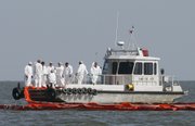 Workers prepare to lay oil boom Wednesday around an island in St. Bernard Parish, La. Area crews found about 130 dead birds and 15 live birds affected by oil Monday.