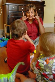 M. Davi Chandrasekaran, center, makes the sign for “wake up” as she tells a story to Phoenix Ferragame, 17 months old, right, and his brother Theo, 3, in the boys’ playroom at their Mount Airy home in Philadelphia.