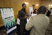 Cedric James, left, Admissions Director with MyComputerCareer.Com, meets with a prospective job applicant at a National Career Fairs Job Fair on July 20 in Plano, Texas. New jobless claims fell last week for the third time in four weeks, but remain above 450,000, where they have been all year.