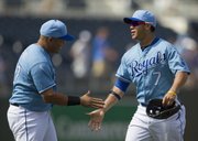 Kansas City’s Gregor Blanco (7) and Brayan Pena celebrate the Royals’ 5-4 victory over the Orioles on Sunday in Kansas City, Mo.