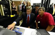 Kansas Rep. Todd Tiahrt checks the results on a laptop along with Doug Henkle, right, and Matthew Stroia, both volunteers for his campaign.