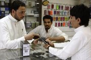 A Saudi customer is served Thursday in a mobile shop at a market in the capital Riyadh, Saudi Arabia. A preliminary agreement between the maker of the BlackBerry smart phone and the kingdom of Saudi Arabia will avert a ban on the phone in that country.