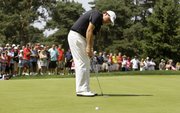 Phil Mickelson makes his putt on the fourth hole for par during the third round of the Bridgestone Invitational. Mickelson, who shot a 71 on Saturday in Akron, Ohio, is four strokes back going into today’s final round.