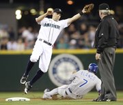 Seattle shortstop Jack Wilson reaches for a high throw as Kansas City’s Gregor Blanco steals second base in the first inning on Saturday in Seattle.