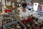 Connie Plessala organizes Louisiana blue crabs into bins Friday behind the counter of Big Fisherman Seafood in New Orleans. The rich fishing grounds of the Gulf of Mexico are beginning to reopen more than three months after crude began gushing from the sea floor. But those who harvest, process and sell the catch face a new crisis: convincing wary consumers it’s not only delicious, but also safe.