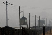 Watch towers and the barbed wire fence of the former Nazi death camp Majdanek are pictured outside the city of Lublin in eastern Poland in this Nov. 9, 2005, file photo. Officials said Tuesday that a fire broke out overnight in one of barracks of Majdanek, destroying more than half of the building and up to 10,000 shoes of Holocaust victims.