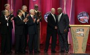 Members of the 1960 U.S. Olympic team applaud as Jerry West, second from right, and Oscar Robertson, right, shake hands during ceremonies at the Naismith Memorial Basketball Hall of Fame on Friday in Springfield, Mass. At far left is former Jayhawk guard Al Kelley.