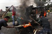 Kashmiri protesters hit a burning government vehicle after they set it on fire during a protest Aug. 4 at Barthana neighborhood in Srinagar, India.