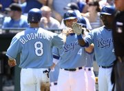 Kansas City’s Willie Bloomquist (8) is congratulated by Wilson Betemit, right, and Alex Gordon after scoring the lone run on Billy Butler’s single in the first inning of a 1-0 victory over the Yankees on Sunday in Kansas City, Mo.