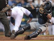 Cleveland Indians catcher Chris Gimenez, right, keeps the ball in his glove after tagging Kansas City Royals’ Mitch Maier out at home as Maier tried to advance on a fly out by Chris Getz during the second inning. The Royals won, though, 9-7, on Wednesday in Kansas City, Mo.