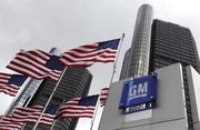 American flags fly outside General Motors world headquarters in Detroit in this April 21, 2009, file photo. General Motors filed the first batch of paperwork Wednesday needed to sell stock to the public, a step that brings the automaker closer to shedding government ownership.