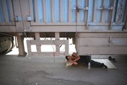 A driver takes a nap Monday under his truck in a traffic jam on an entrance ramp to the Beijing-Tibet Highway in Guoleizhuang township, in north China’s Hebei province.