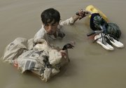 A Pakistani man negotiates floodwaters with his chickens Saturday at the remote villages of Ali Pur town in Muzaffargarh district, Punjab Province, Pakistan. Floodwaters made another break Saturday in the levees protecting a southern Pakistani city, as thousands of residents fled for high ground and left the city nearly empty.