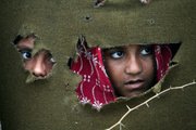 Pakistani flood survivors look out from their makeshift tent Friday after fleeing their village in Sajawal near Hyderabad, Pakistan.