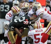 Oakland running back Darren McFadden (20) is tackled during a preseason game against San Francisco on Saturday in Oakland, Calif. The 49ers won, 28-24.