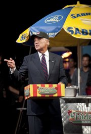 Vice President Joe Biden hands out hot dogs to the troops during an appearance Wednesday on the “Colbert Report” in this photo provided by Comedy Central.