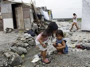 Girls play beside an open sewer Sept. 2 in the sprawling slum on the edge of the Philippines’ Manila Bay. The U.N. is holding a summit starting Monday to review progress being made to tackle poverty, disease, ignorance and inequality.