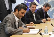 Mahmoud Ahmadinejad, President of Iran, signs a guest book during a meeting with United Nations Secretary-General Ban Ki-moon on Sunday at the United Nations in New York.