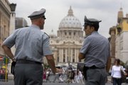 Italian financial police officers talk to each other in front of St. Peter’s square Tuesday at the Vatican. Just when the Catholic Church didn’t need another scandal, Italian authorities have seized $30 million from a Vatican bank account and begun investigating top officials of the Vatican bank in connection with a money laundering probe.