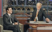 Actor Joaquin Phoenix, left, joins host David Letterman on the set of the “Late Show with David Letterman” Wednesday in New York. It was Phoenix’s first visit to the CBS broadcast since February 2009.