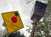 A photo-enforced stop sign camera and warning sign are seen Tuesday at the Top Of Topanga overlook in Topanga, Calif.