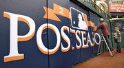 Todd Anderson, on ladder, and Jill Goldsmith put up a Major League Baseball Postseason banner Monday on the right-field wall at Tropicana Field in St. Petersburg, Fla. The Rays and Rangers kick off the playoffs Wednesday.