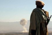An Afghan northern alliance Mujahed looks at a plume of smoke rising from the Taliban village of Khanaqa in the Parwan province from his position at the Mahmood Raqy frontline in the Kapisa province, 30 miles from the Afghan capital Kabul, in this Nov. 7, 2001, file photo. An aircraft had just released its load of bombs as part of the U.S. attempt to help the northern alliance to advance toward the capital and other key areas.
